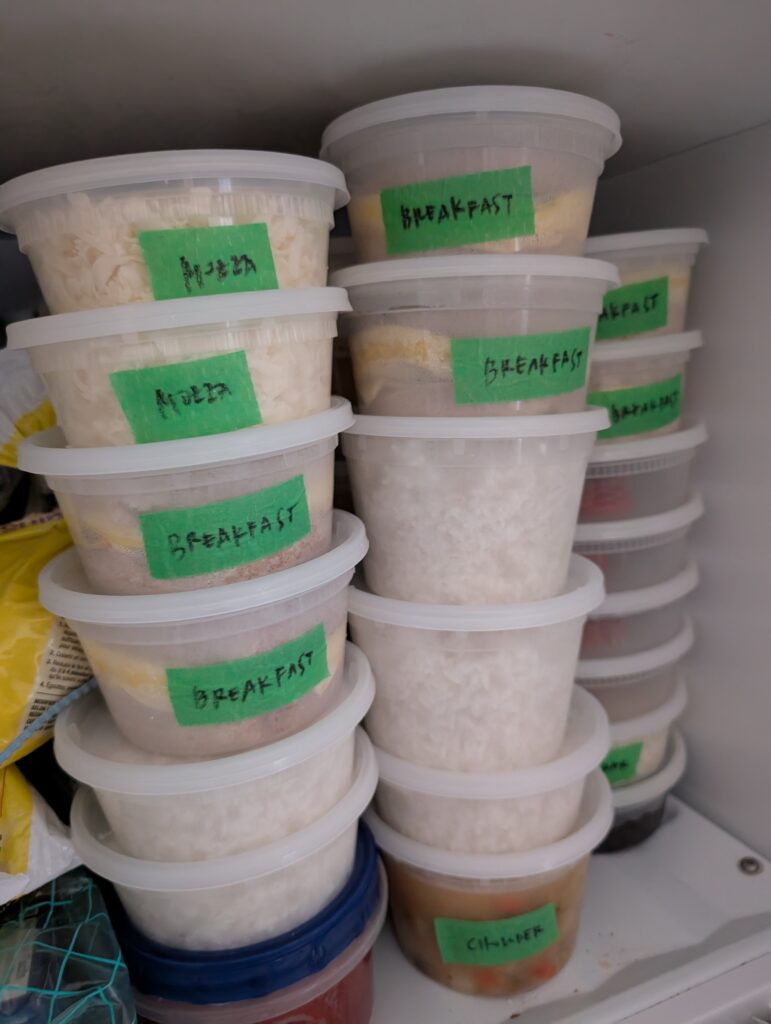 Another view of my freezer from a different day, with a stack of deli containers filled with rice or breakfast sandwiches.